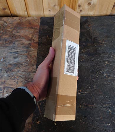 Photo of a hand holding a small carboard box package